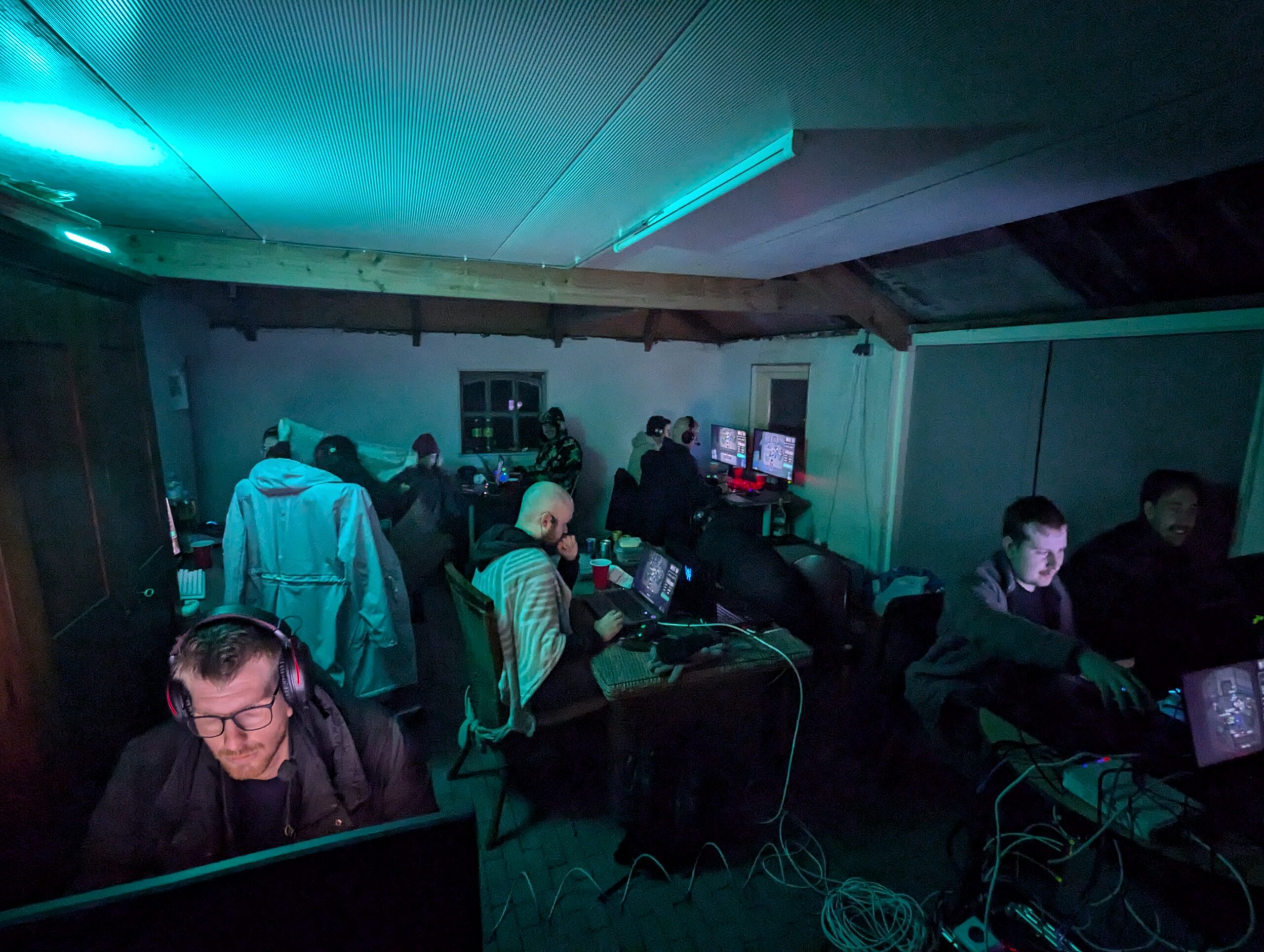 Avondopname van de Loef-LAN LAN-party met deelnemers aan computers, RGB-verlichting en een gezellige game-omgeving.