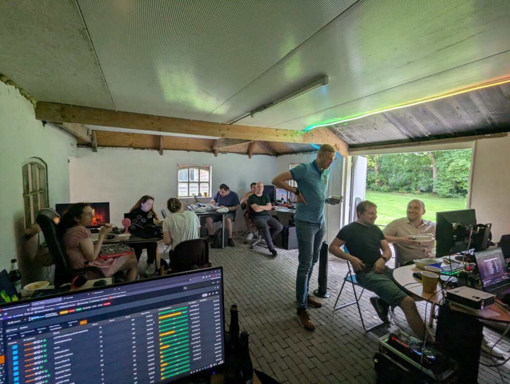 Gezellige LAN-party bij LOEF-LAN met deelnemers aan computers en een ontspannen sfeer in een landelijke omgeving.
