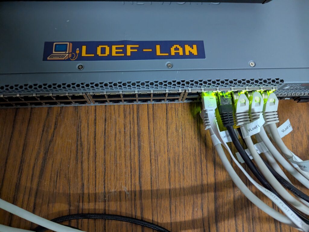 LOEF-LAN netwerkswitch met knipperende poorten en aangesloten kabels voor een LAN-party setup.